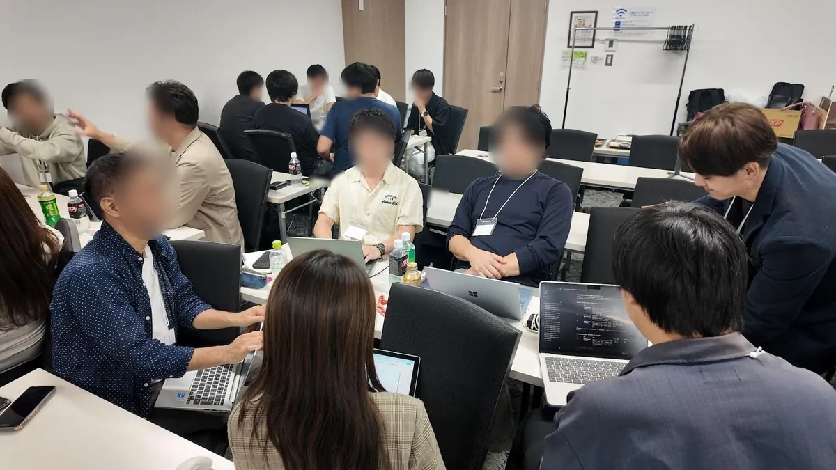 テーブルを回って参加者にアドバイスするこうじ